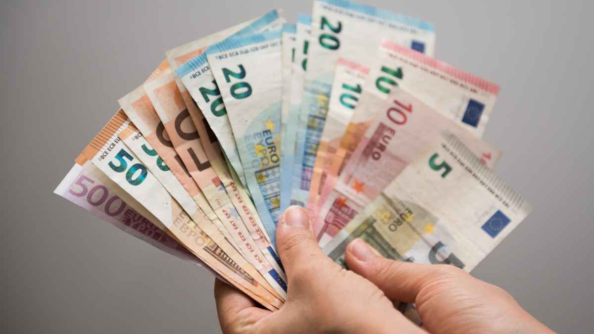 Mano sosteniendo varios billetes de euro en diferentes denominaciones