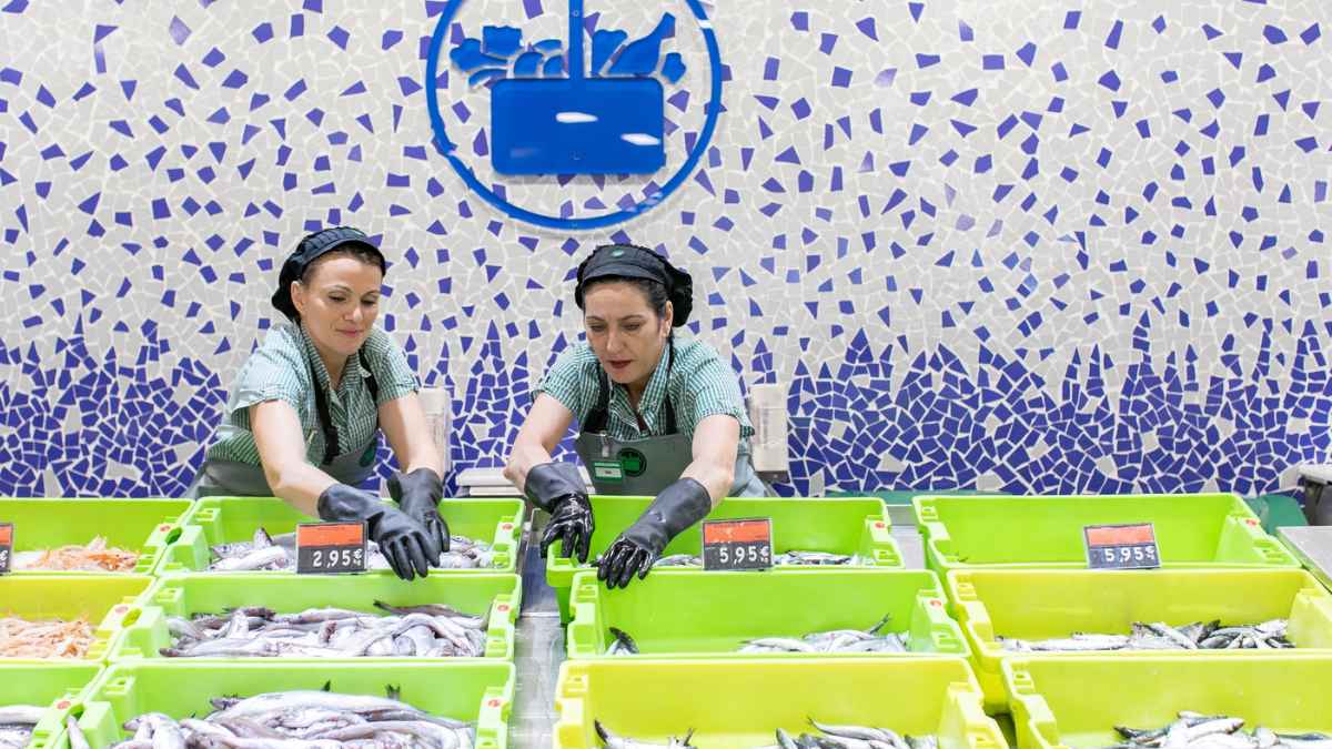 Trabajadoras de Mercadona en pescadería con pescado limpio en bandejas reciclables